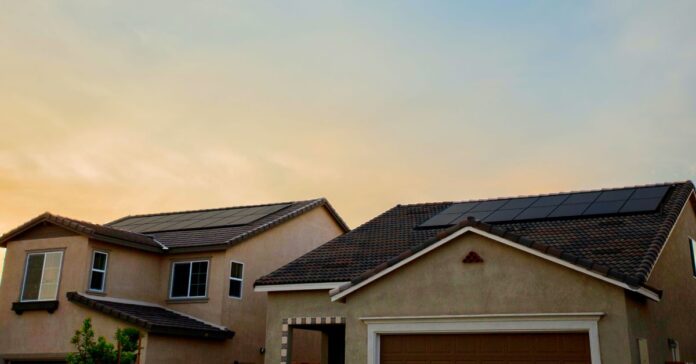 solar energy negatives - the image shows a house with some solar panels at the roof and, behind it, the sunset